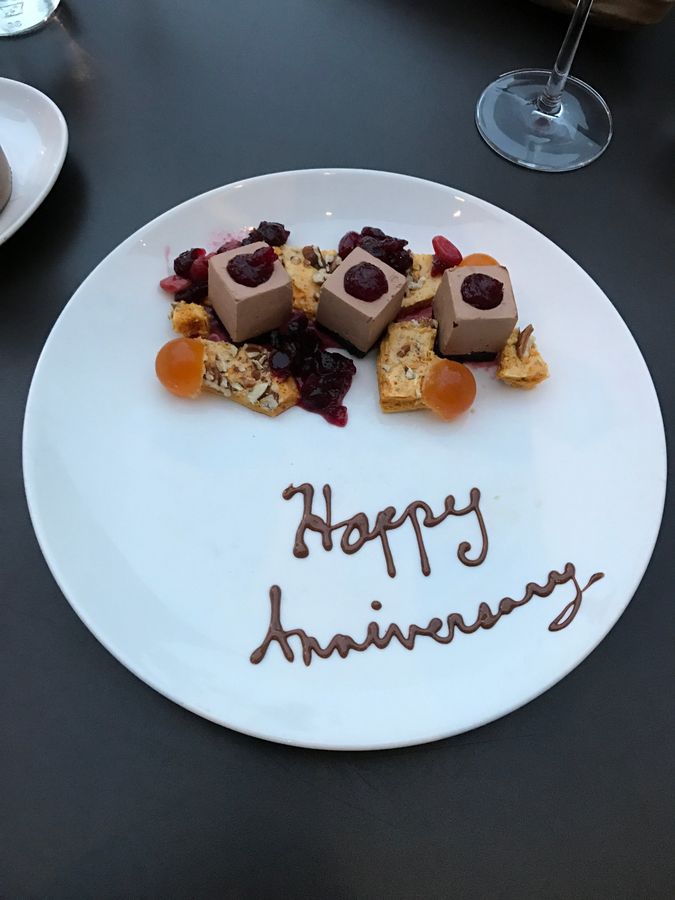 A dessert plate with Happy Anniversary written in chocolate