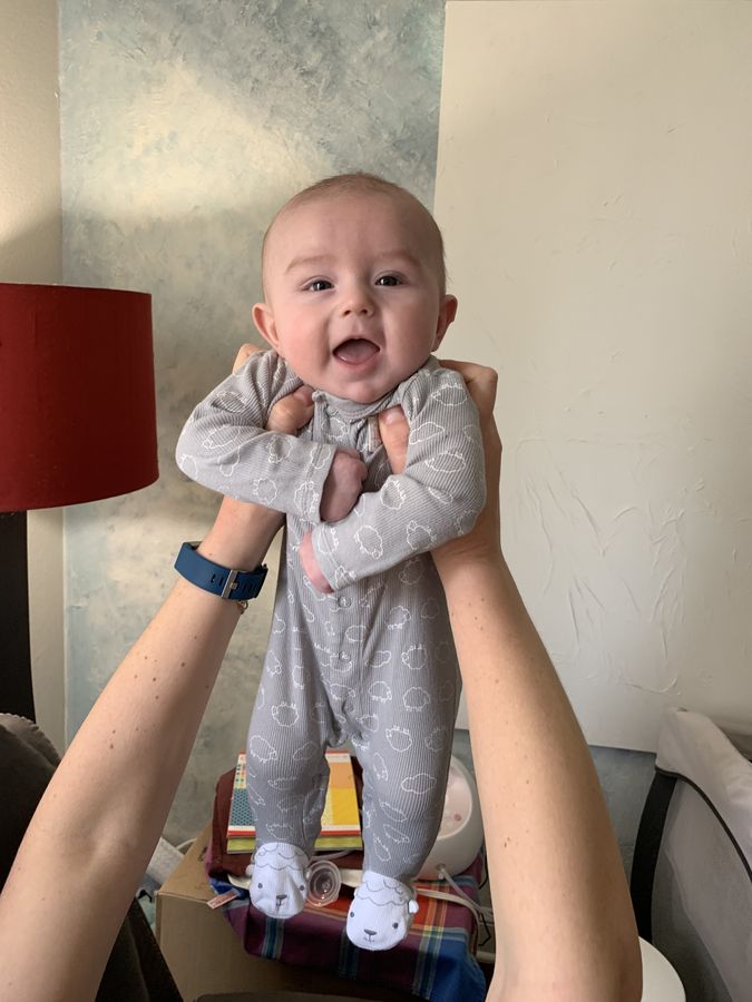 A grinning baby held up high
